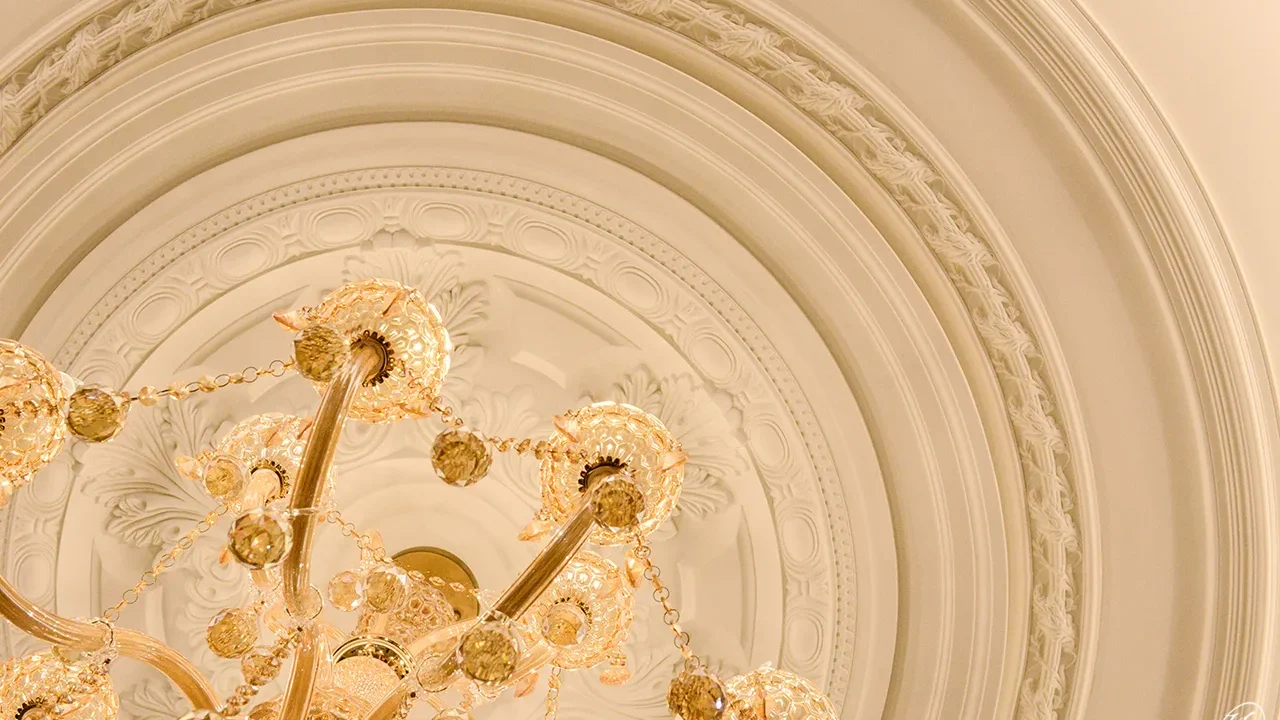 客廳天花板以平面燈座、圓弧外框、梳狀線板，一圈一圈、一層一層的堆砌，打造出類似多層蛋糕的造型